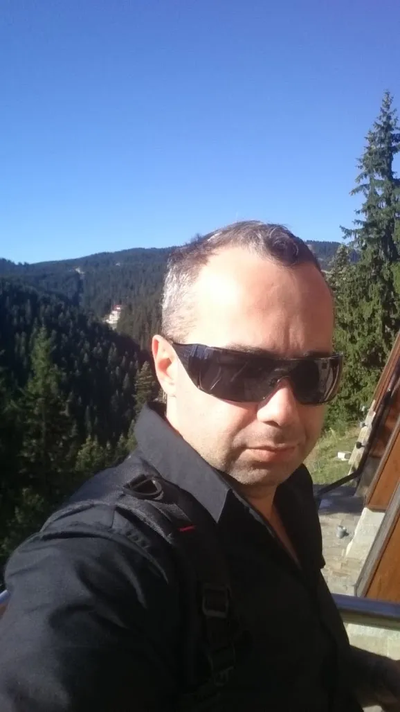 Ivan Pasev wearing sunglasses in a mountain landscape.