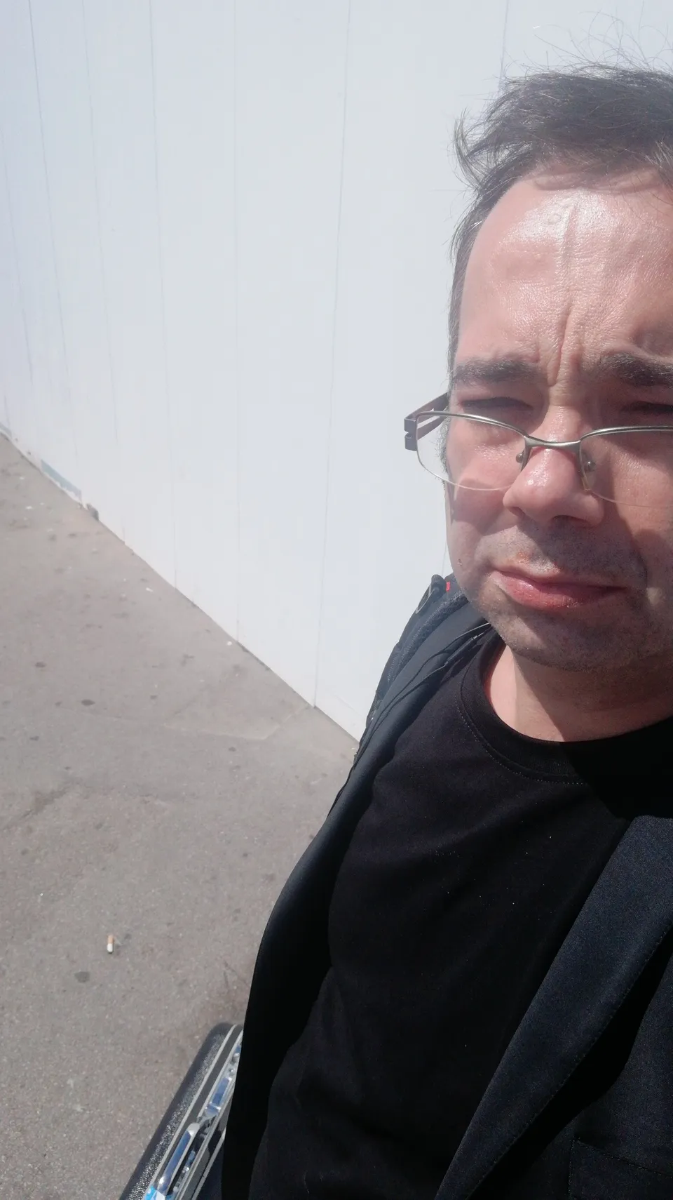 Ivan Pasev in dark clothing outdoors with a travel case partly visible.
