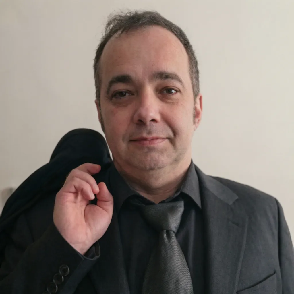 Portrait of Ivan Pasev in a dark shirt against a light background.